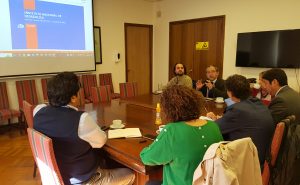 Autoridades conversando en la reunión, mirando la presentación del INH.