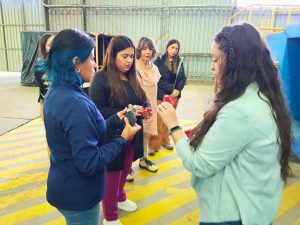 Dos funcionarias INH y la delegada presidencial sostienen dolos de distintos colores en sus manos.