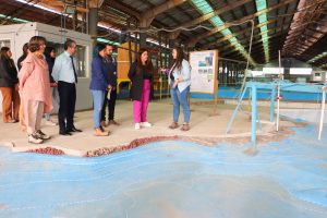 Personas de pie, en el modelo físico de una caleta.