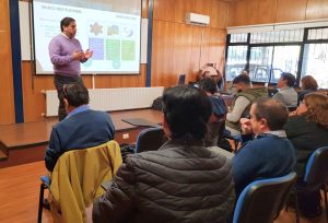 Persona parada frente a integrantes del comité sentados.