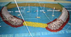 Modelo 3D de proyecto playa artificial estudiada en instalaciones del INH, nótese la construcción de rompeolas y la instalación de sondas al interior de la dársena para medir la agitación dentro de la zona abrigo.